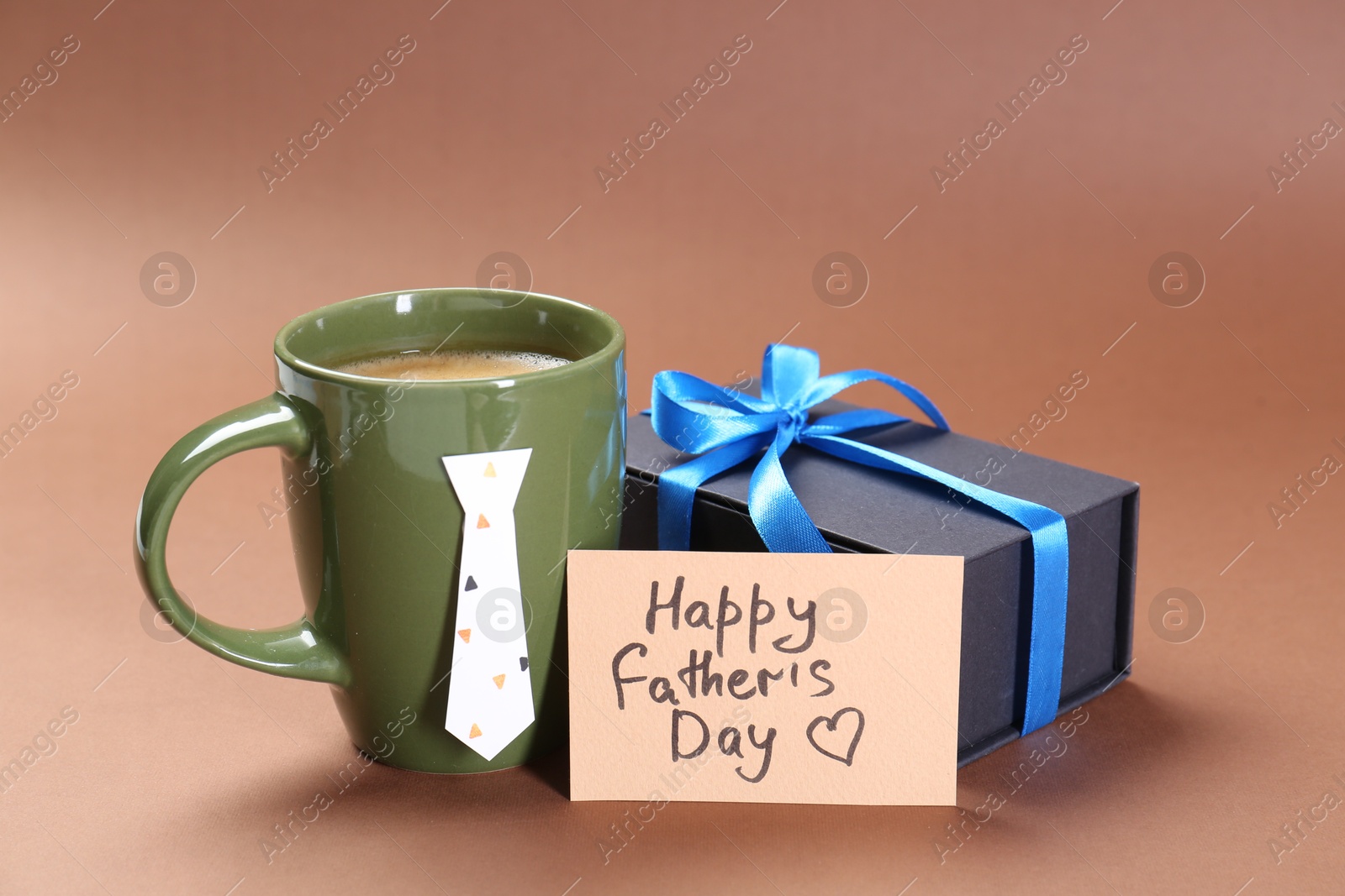 Photo of Card with phrase Happy Father's Day, coffee and gift on brown background