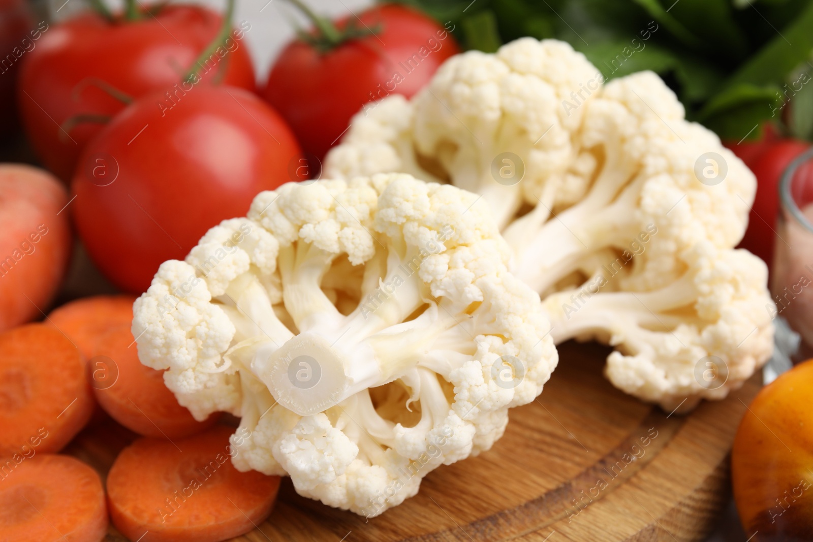 Photo of Cooking tasty stew. Cauliflower, tomatoes and carrot on table, closeup