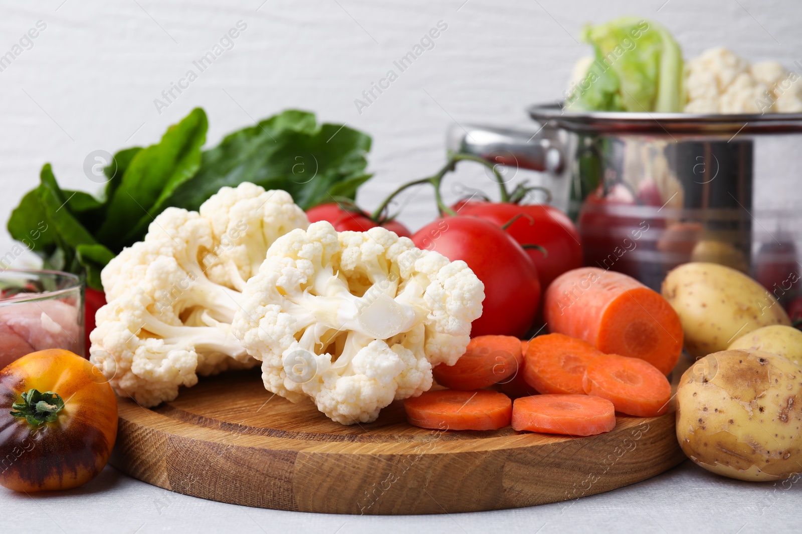 Photo of Cooking tasty stew. Different fresh vegetables on light grey table