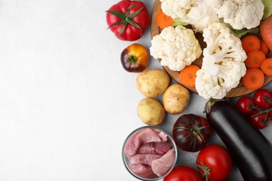 Photo of Different vegetables and raw meat for stew on light grey table, top view. Space for text