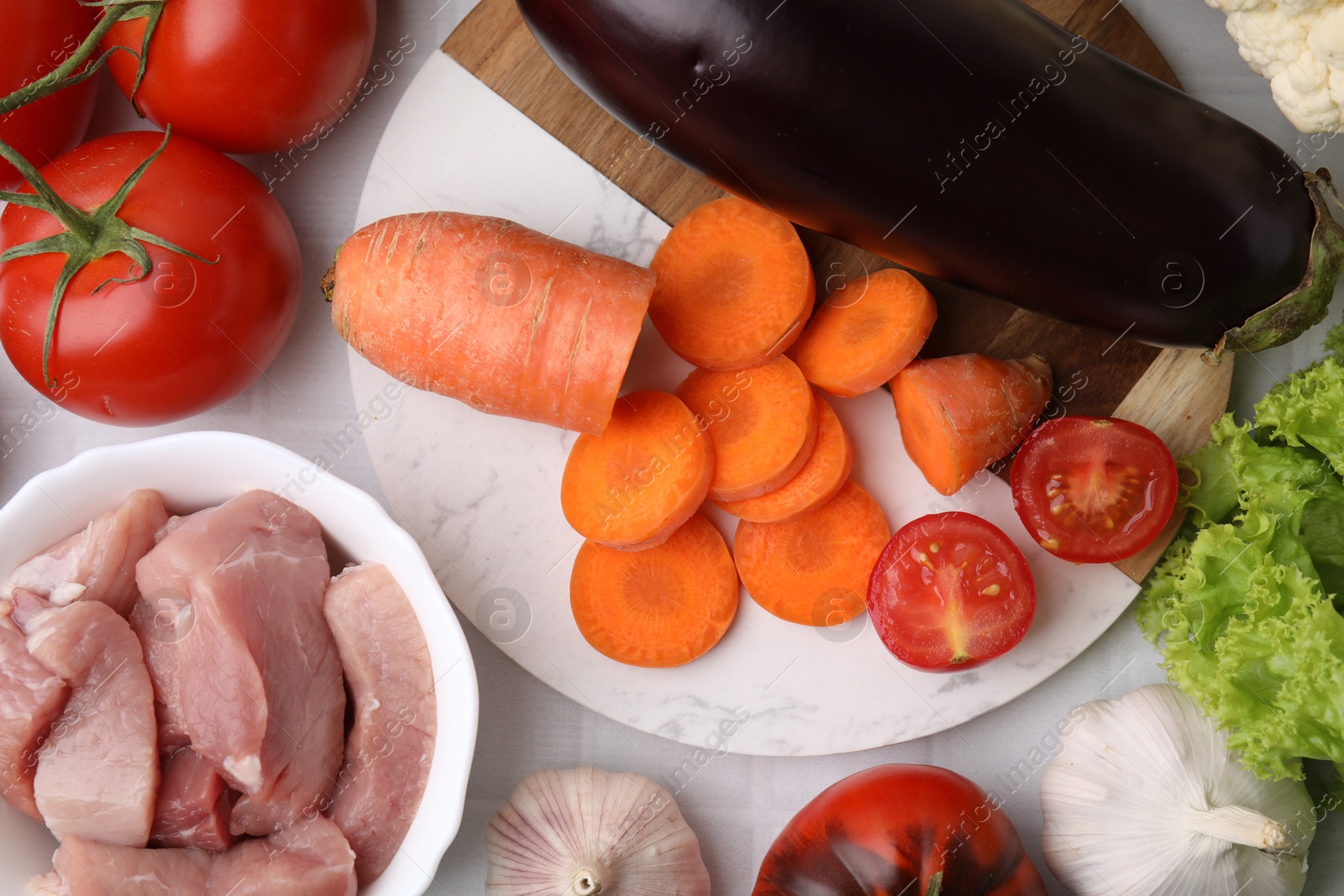 Photo of Different vegetables and raw meat for stew on table, top view