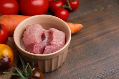 Cooking tasty stew. Raw meat, tomatoes and carrot on wooden table, space for text