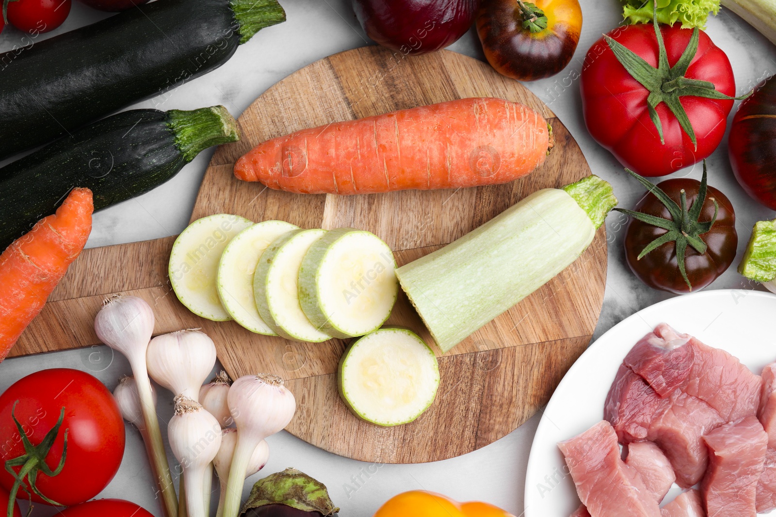 Photo of Different vegetables and raw meat for stew on table, top view