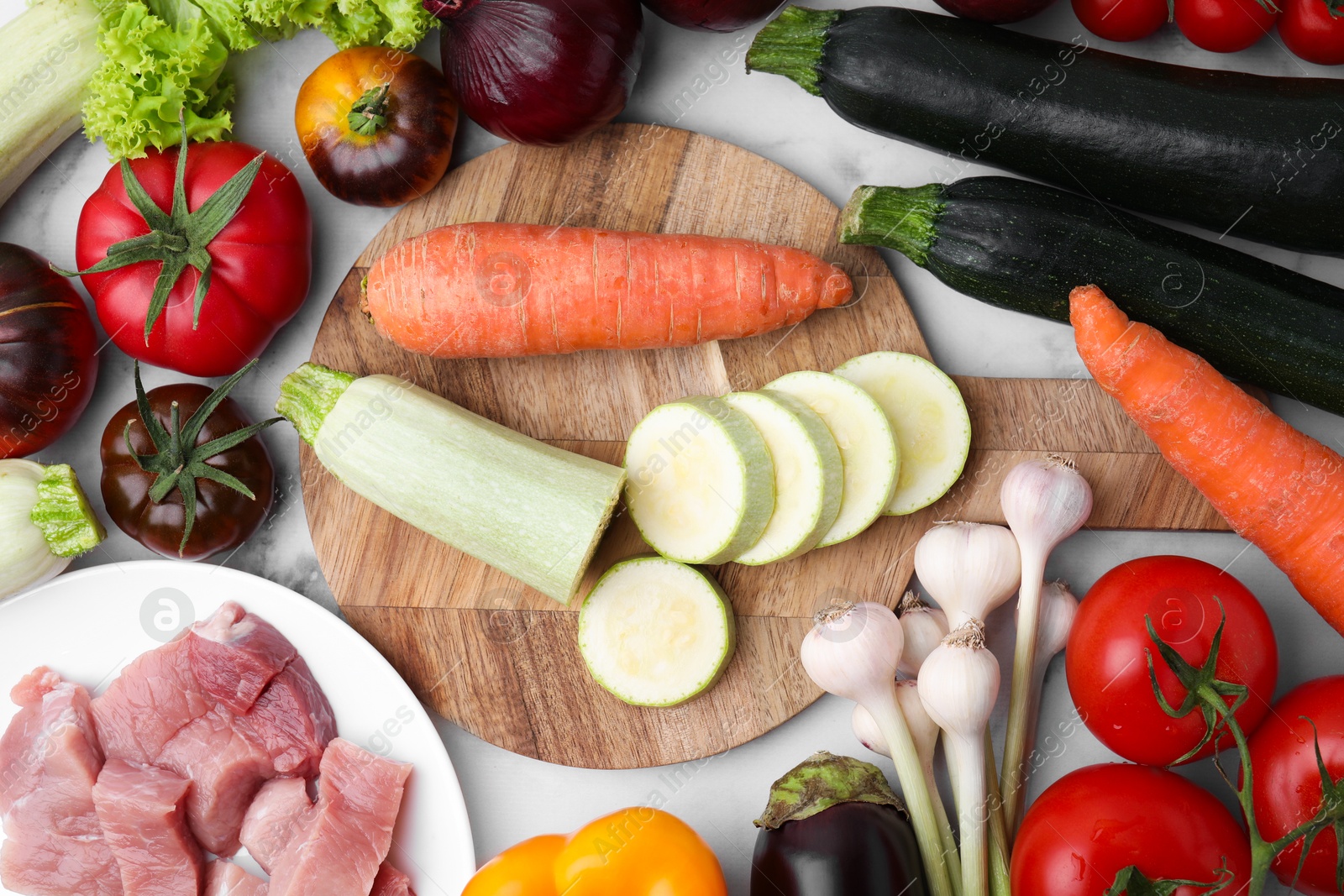 Photo of Different vegetables and raw meat for stew on table, top view