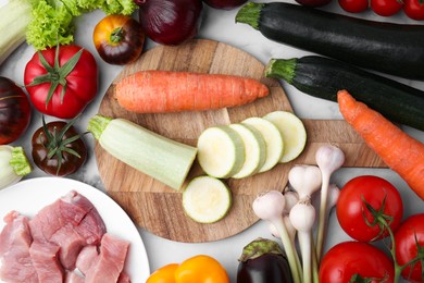 Photo of Different vegetables and raw meat for stew on table, top view