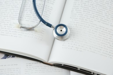 One new medical stethoscope and books on table, above view