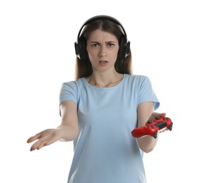 Photo of Disappointed woman in headphones with controller on white background