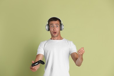 Photo of Surprised man controller on light green background