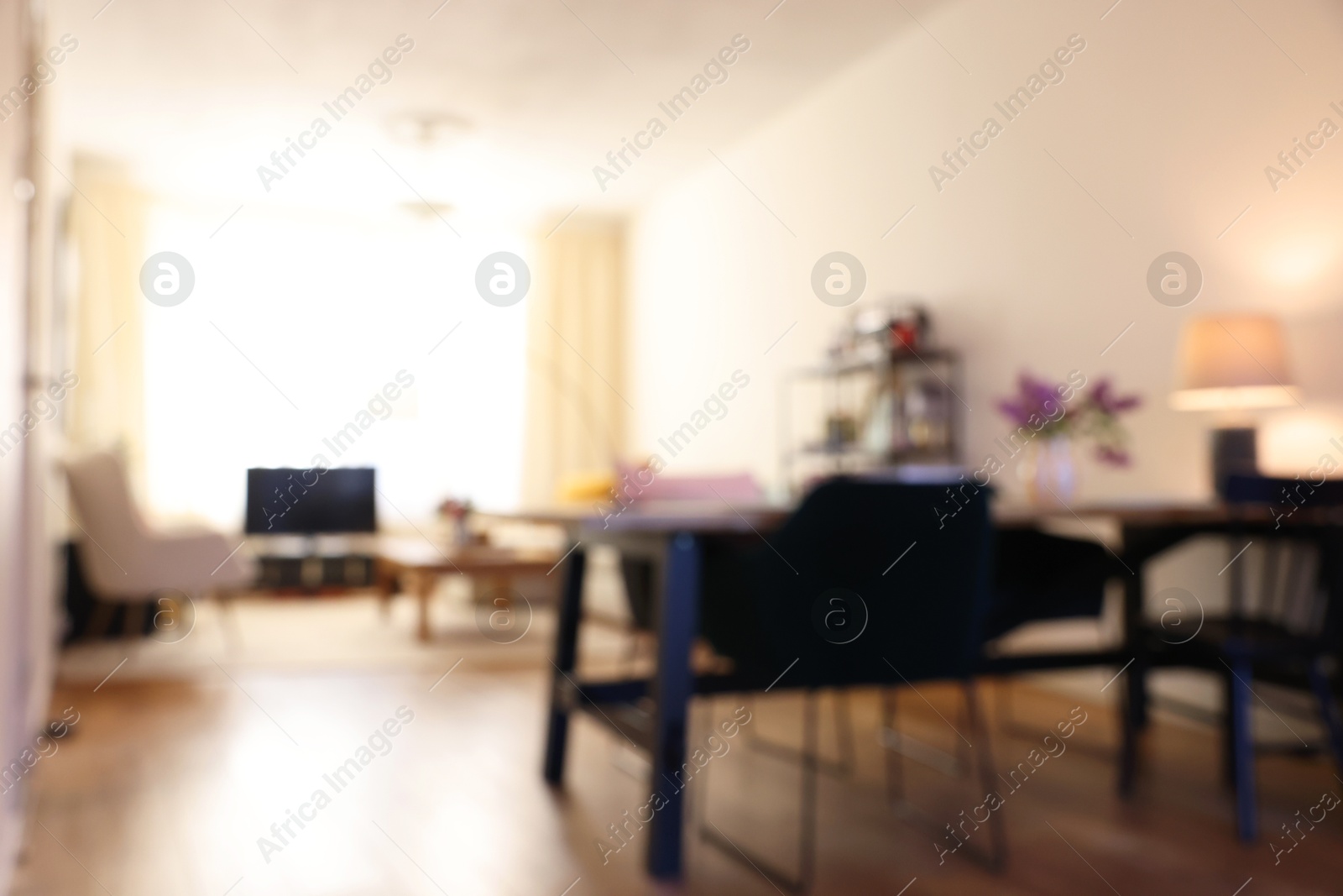 Photo of Stylish dining room interior with comfortable furniture and bouquet of flowers, blurred view