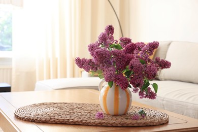 Photo of Beautiful fragrant lilac flowers in vase on table at home. Space for text