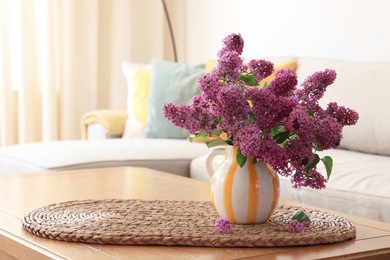 Photo of Beautiful fragrant lilac flowers in vase on table at home. Space for text