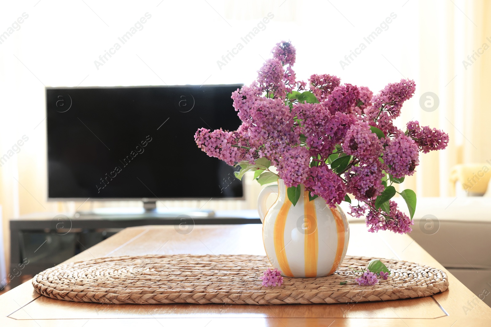 Photo of Beautiful fragrant lilac flowers in vase on table at home. Space for text