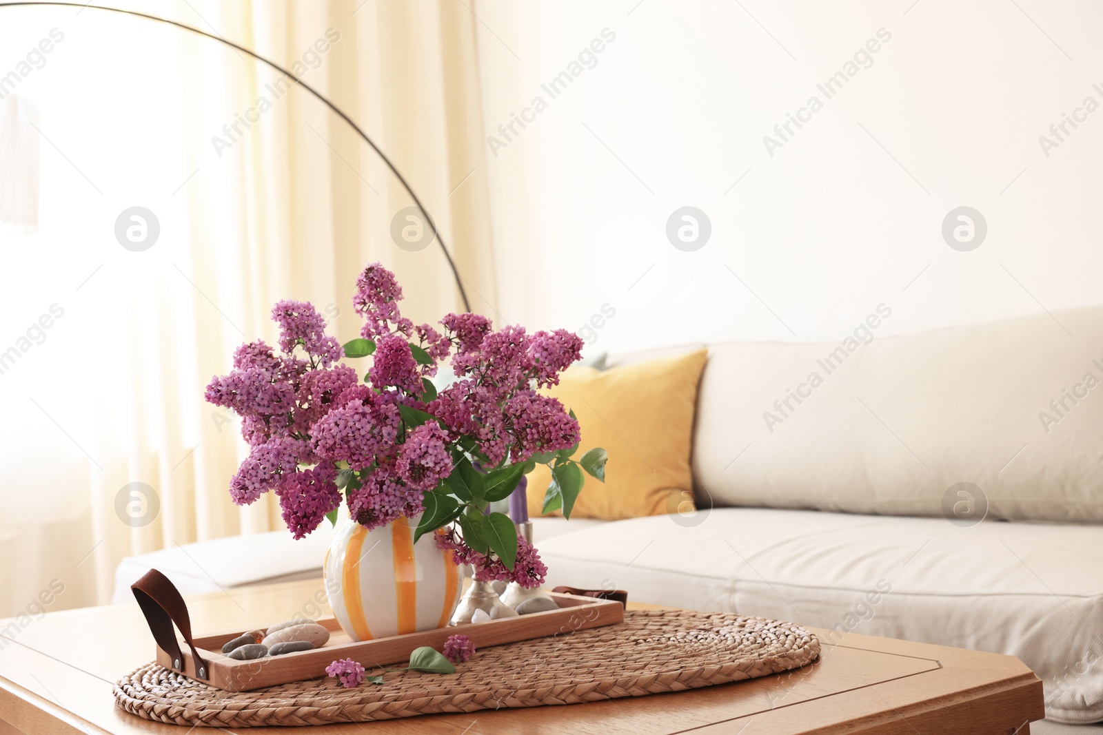 Photo of Beautiful fragrant lilac flowers in vase on table at home. Space for text