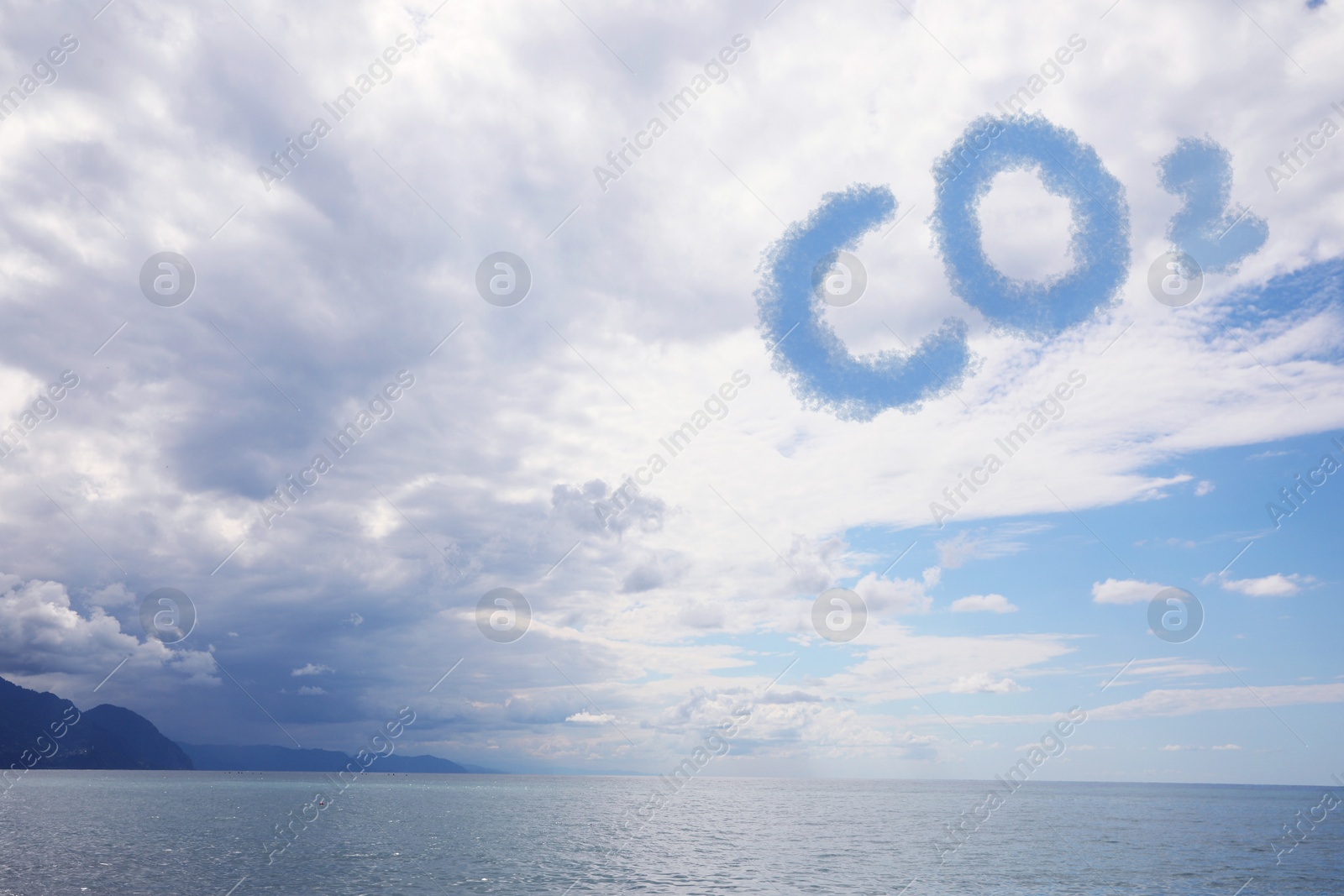 Image of Blue sky with CO2 chemical formula and clouds over sea. Carbon dioxide emissions