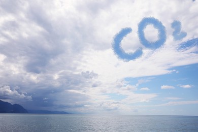 Image of Blue sky with CO2 chemical formula and clouds over sea. Carbon dioxide emissions