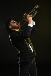 Photo of Professional musician playing trumpet on black background