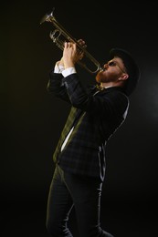 Professional musician playing trumpet on black background