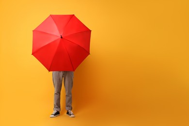 Photo of Man with red umbrella on yellow background, space for text