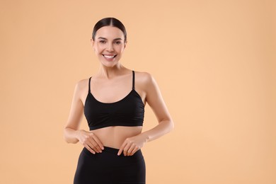 Photo of Diet and weight loss concept. Beautiful young woman with slim body against beige background. Space for text