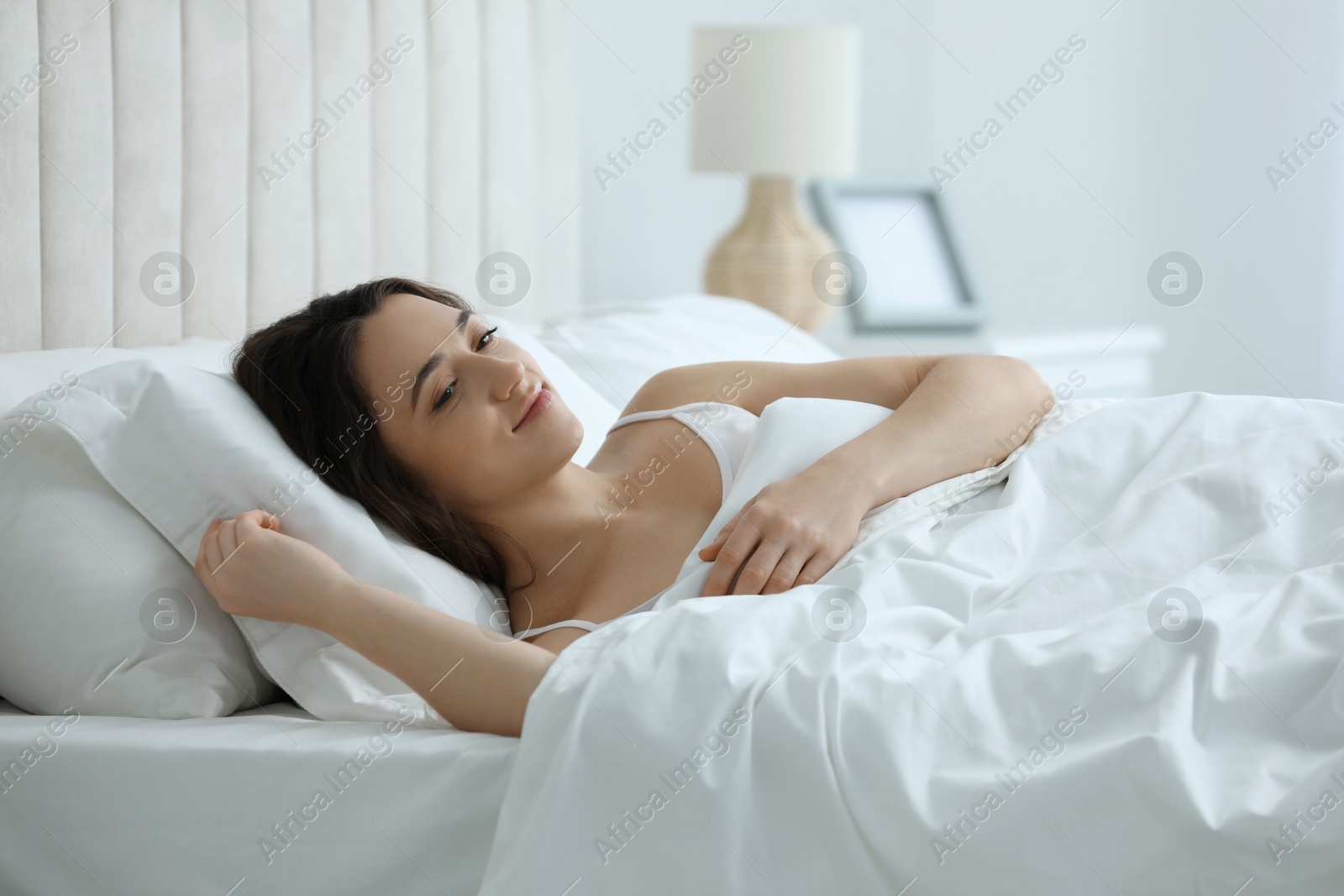 Photo of Bedtime. Beautiful woman lying in bed at home