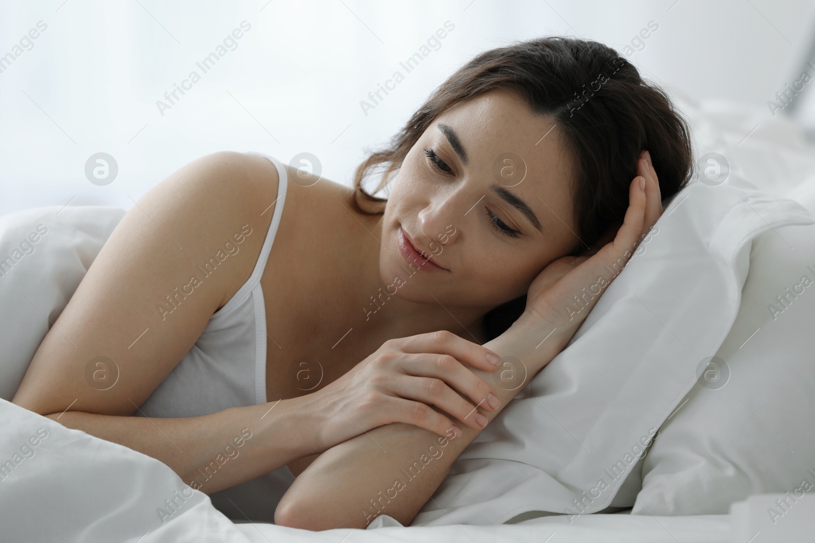 Photo of Bedtime. Beautiful woman lying in bed at home