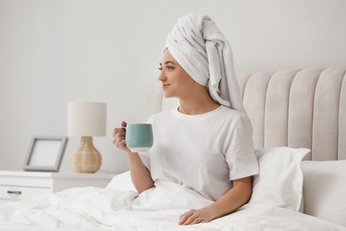 Photo of Woman in towel drinking coffee in bed. Good morning