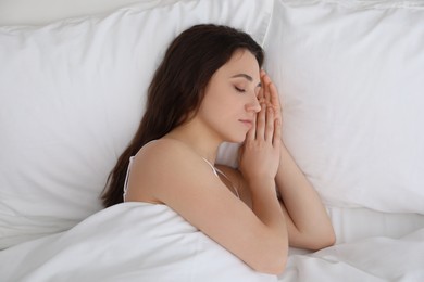 Photo of Bedtime. Beautiful woman sleeping in bed indoors, top view