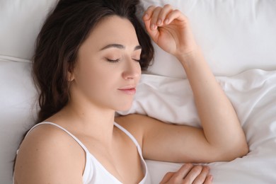 Photo of Bedtime. Beautiful woman sleeping on bed in morning, top view