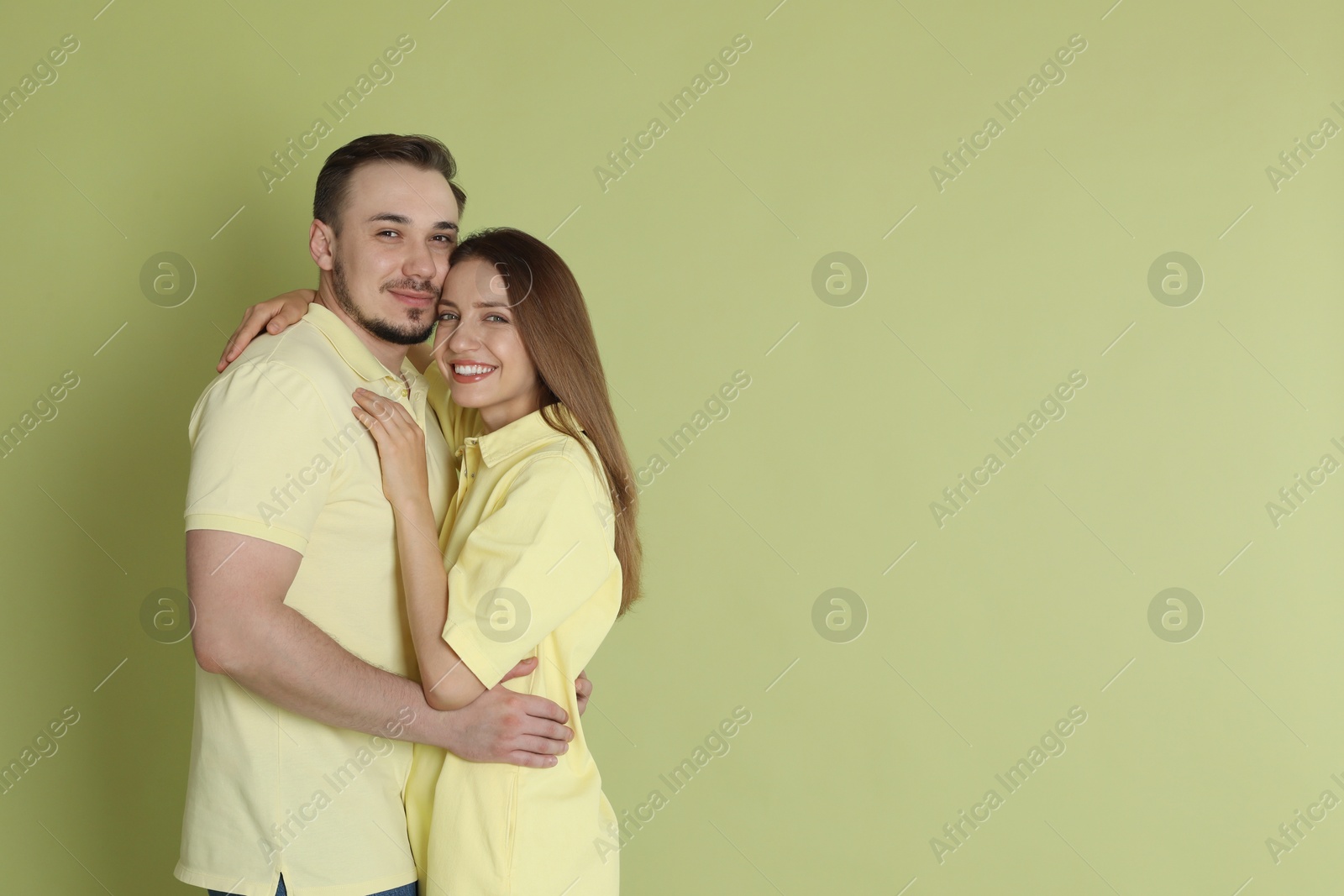 Photo of Happy couple hugging on green background. Space for text