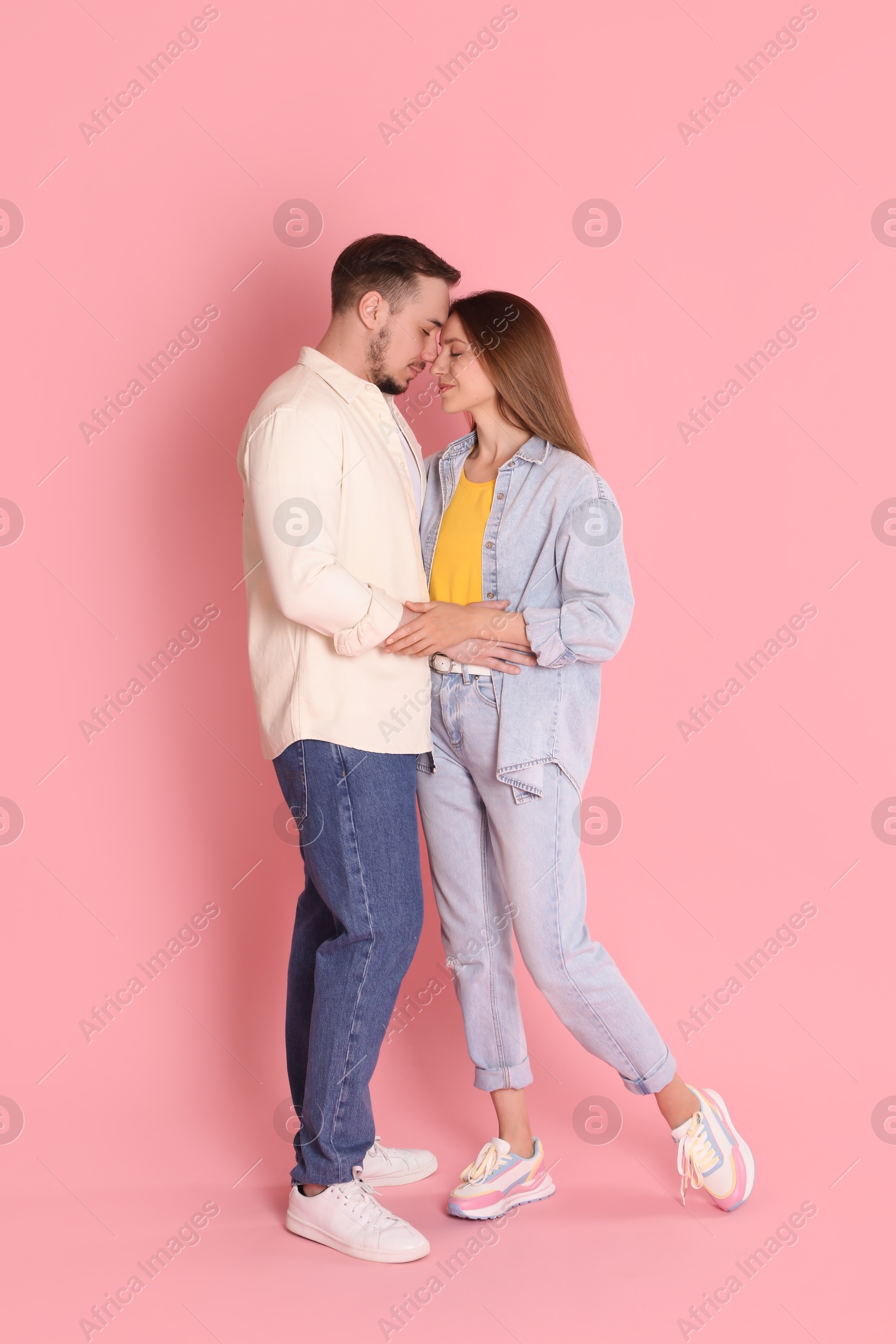 Photo of Cute couple hugging on pink background. Strong relationship