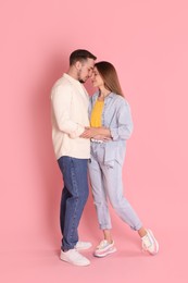 Cute couple hugging on pink background. Strong relationship