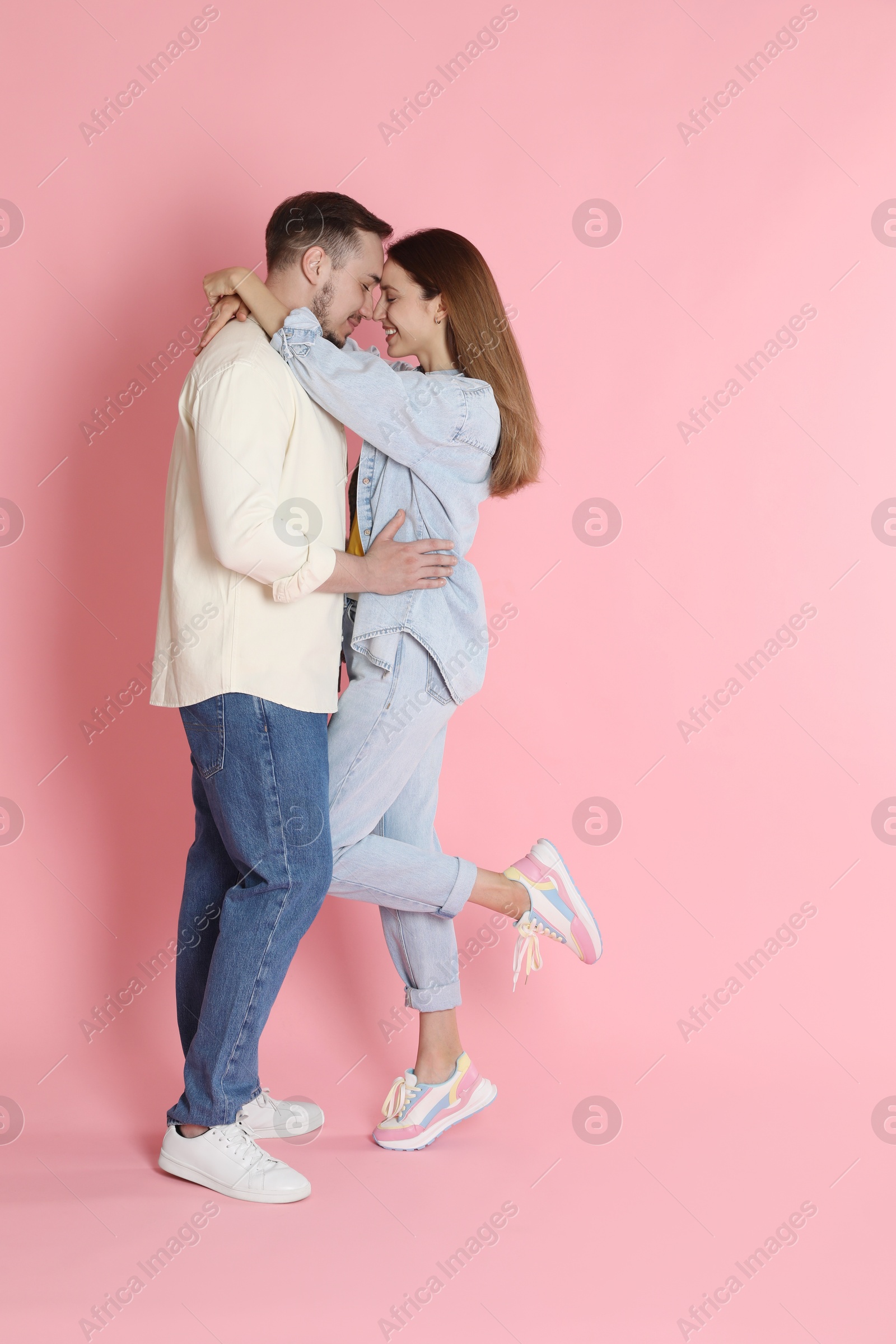 Photo of Cute couple hugging on pink background. Strong relationship