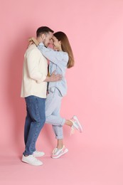 Photo of Cute couple hugging on pink background. Strong relationship