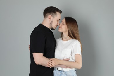 Happy couple hugging on grey background. Strong relationship