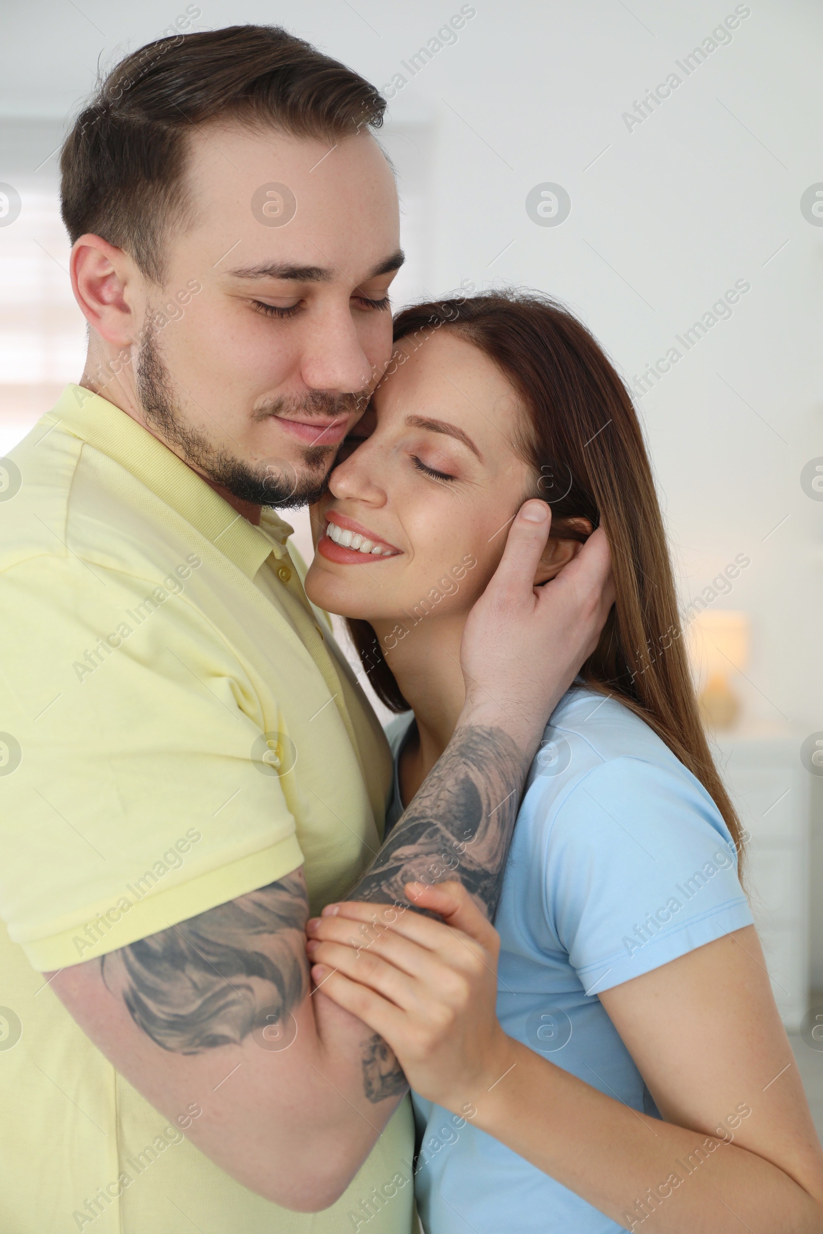 Photo of Man hugging his happy girlfriend at home