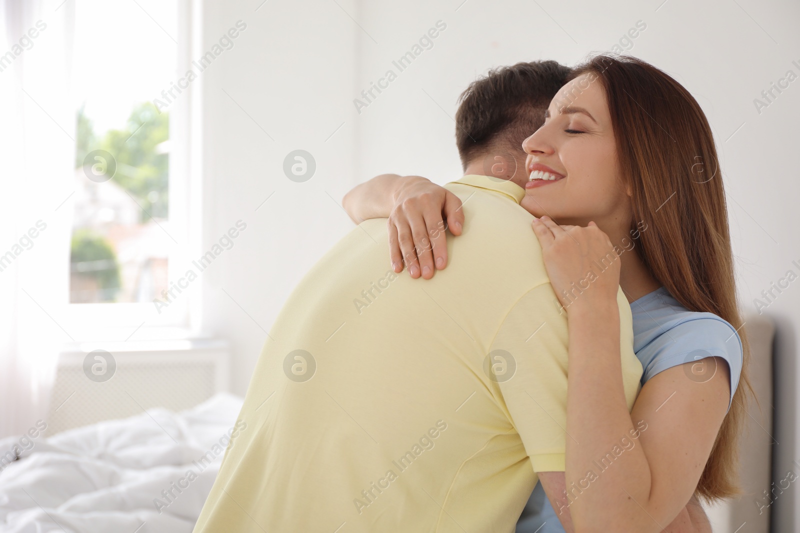 Photo of Happy woman hugging her boyfriend at home. Space for text