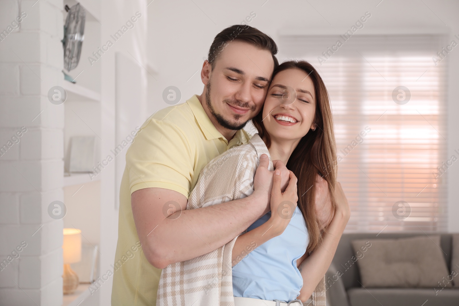 Photo of Man hugging his happy girlfriend at home