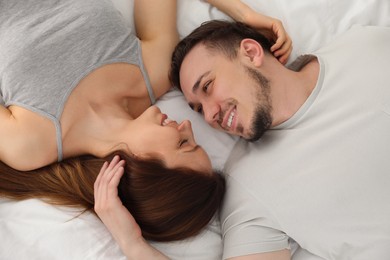 Family portrait of lovely couple on bed at home, top view