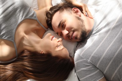 Family portrait of lovely couple on bed at home, top view