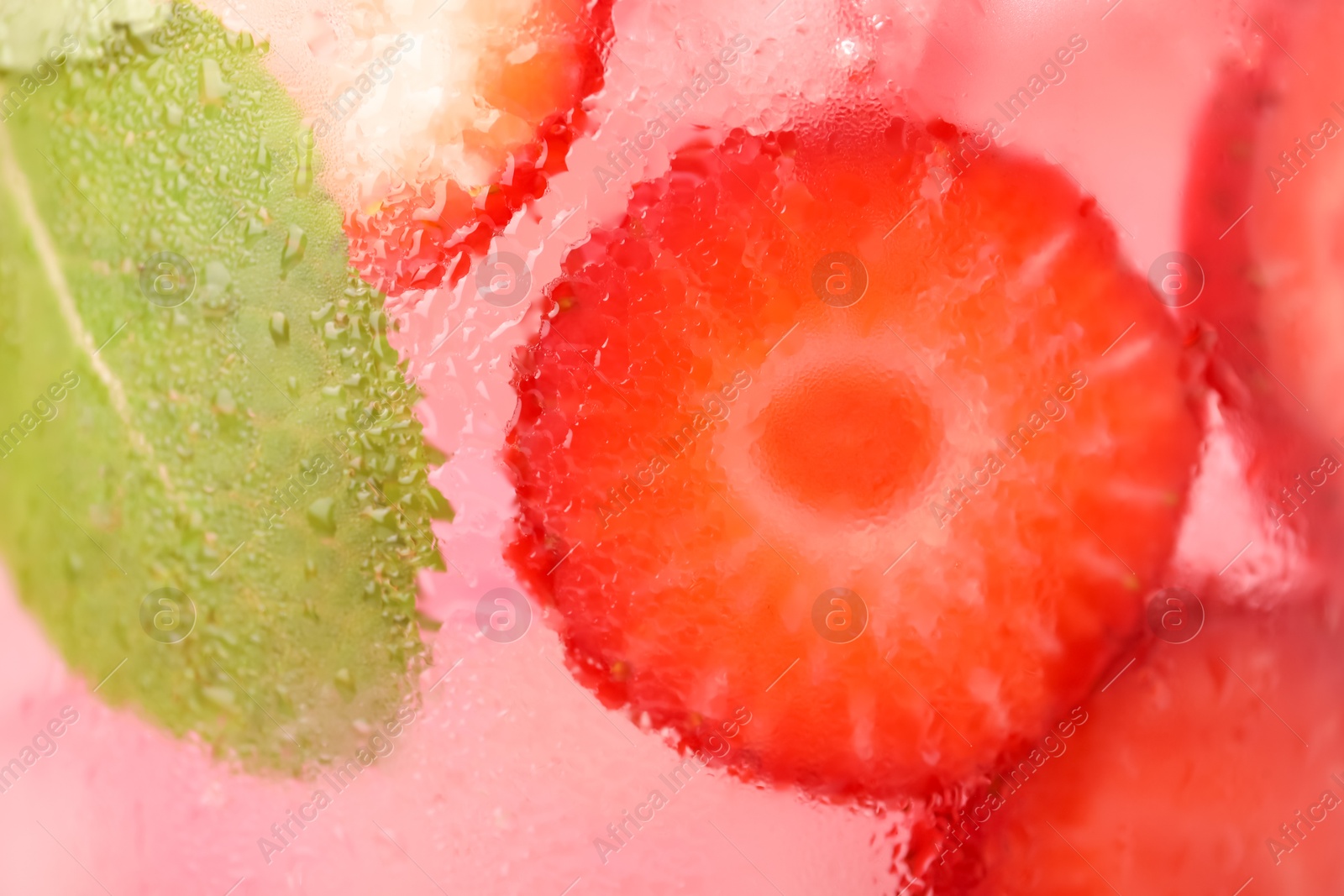 Photo of Freshly made strawberry lemonade with mint in jug as background, closeup