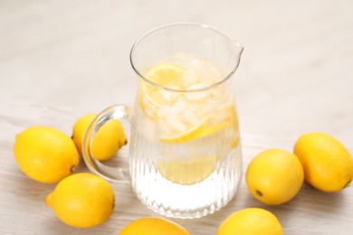 Photo of Freshly made lemonade in jug on white wooden table