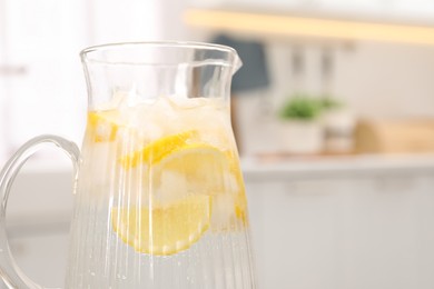 Photo of Freshly made lemonade in jug on table indoors, closeup. Space for text