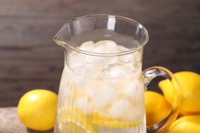 Photo of Freshly made lemonade in jug on table, closeup