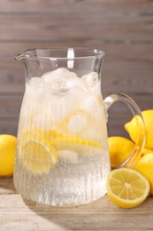 Freshly made lemonade in jug on wooden table