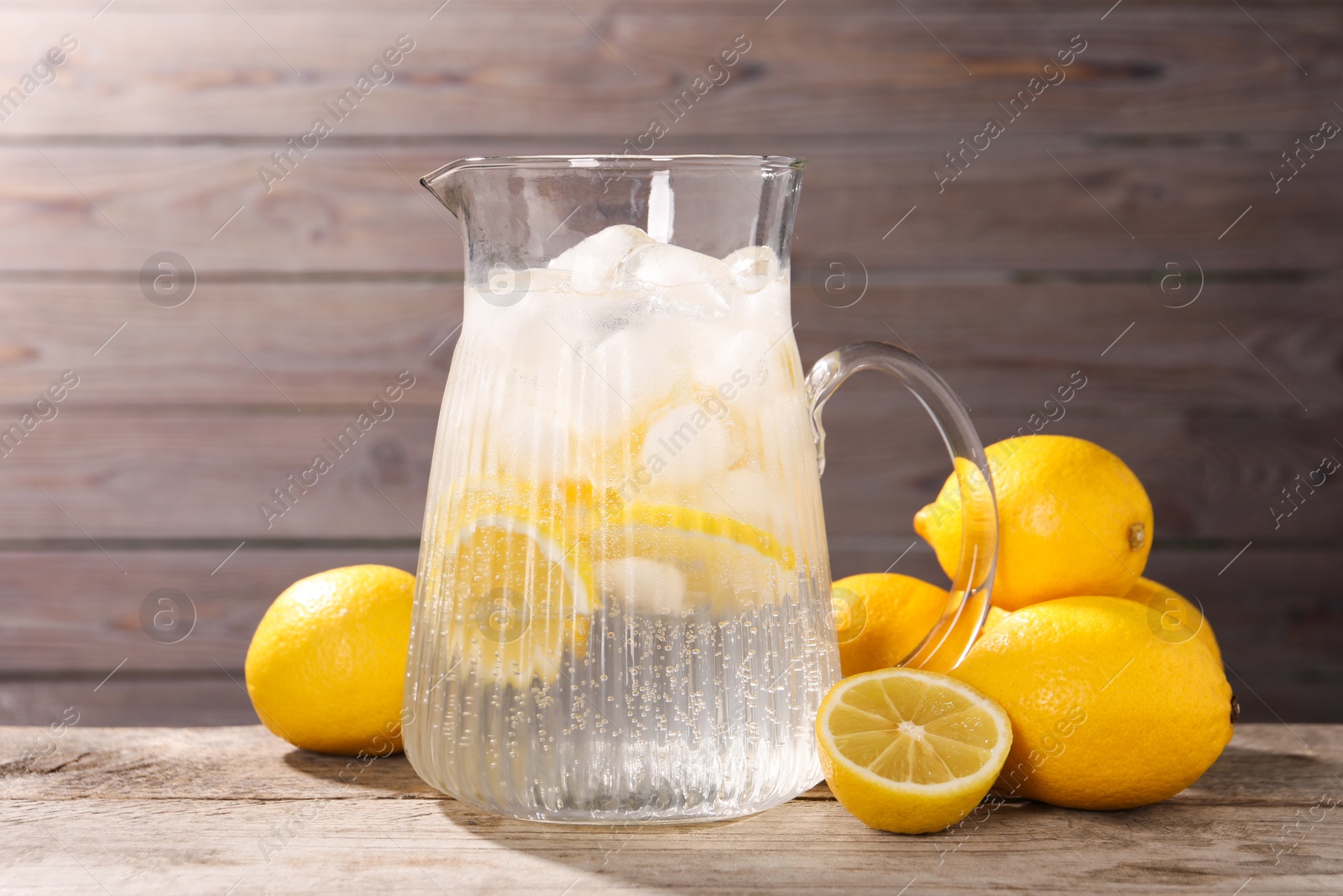 Photo of Freshly made lemonade in jug on wooden table