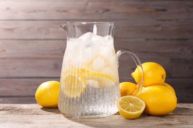 Photo of Freshly made lemonade in jug on wooden table