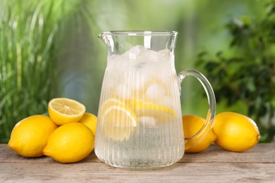 Freshly made lemonade in jug on wooden table outdoors