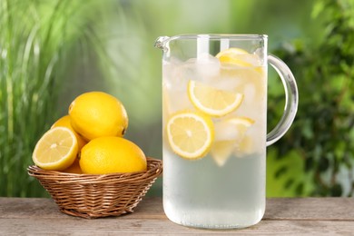 Freshly made lemonade in jug on wooden table outdoors