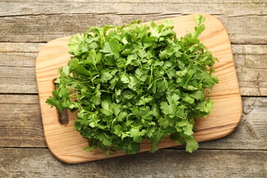 Photo of Fresh coriander on wooden table, top view