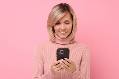 Photo of Happy woman with phone on pink background